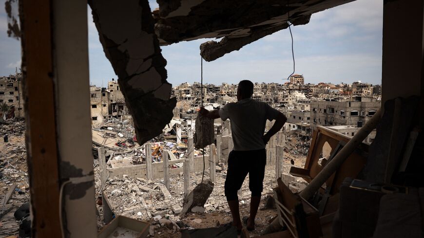  A Palestinian man looks at a ravaged neighborhood from a destroyed apartment in Khan Younis in the southern Gaza Strip, May 2, 2024.